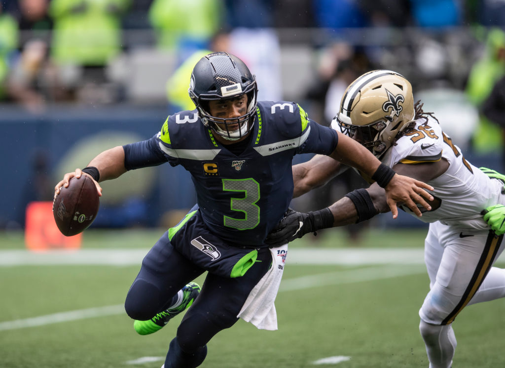 Super Bowl champion Russell Wilson avoids a tackle in an NFL game.