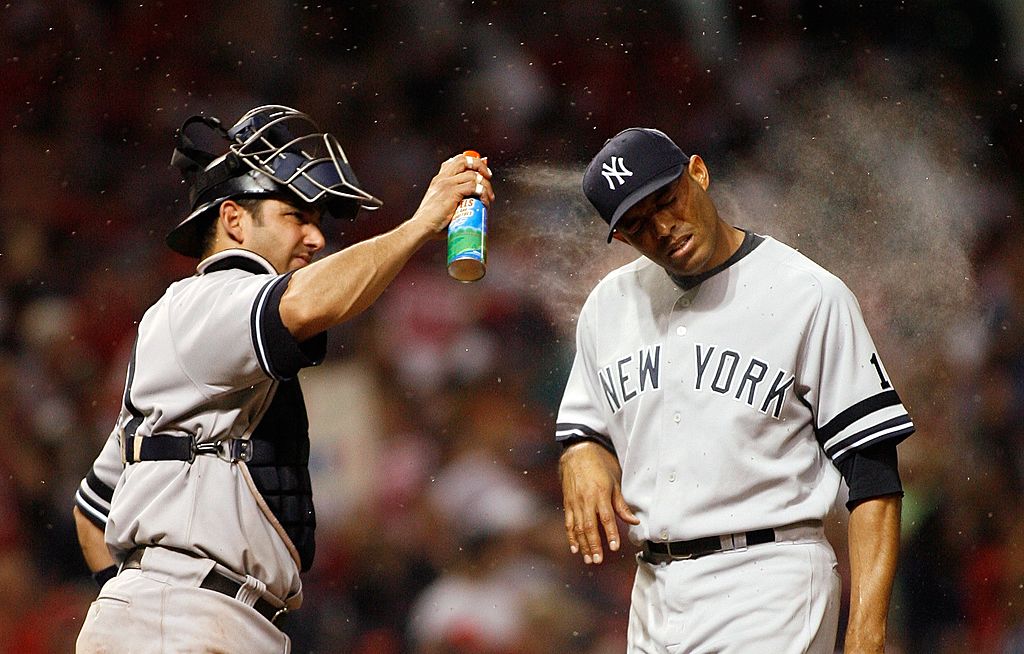 Yankees catcher Jorge Posada spraying pitcher Mariano Rivera with bug spray