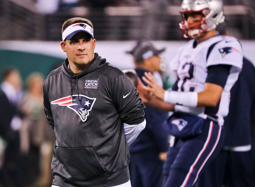 New England Patriots offensive coordinator Josh McDaniels standing with Tom Brady