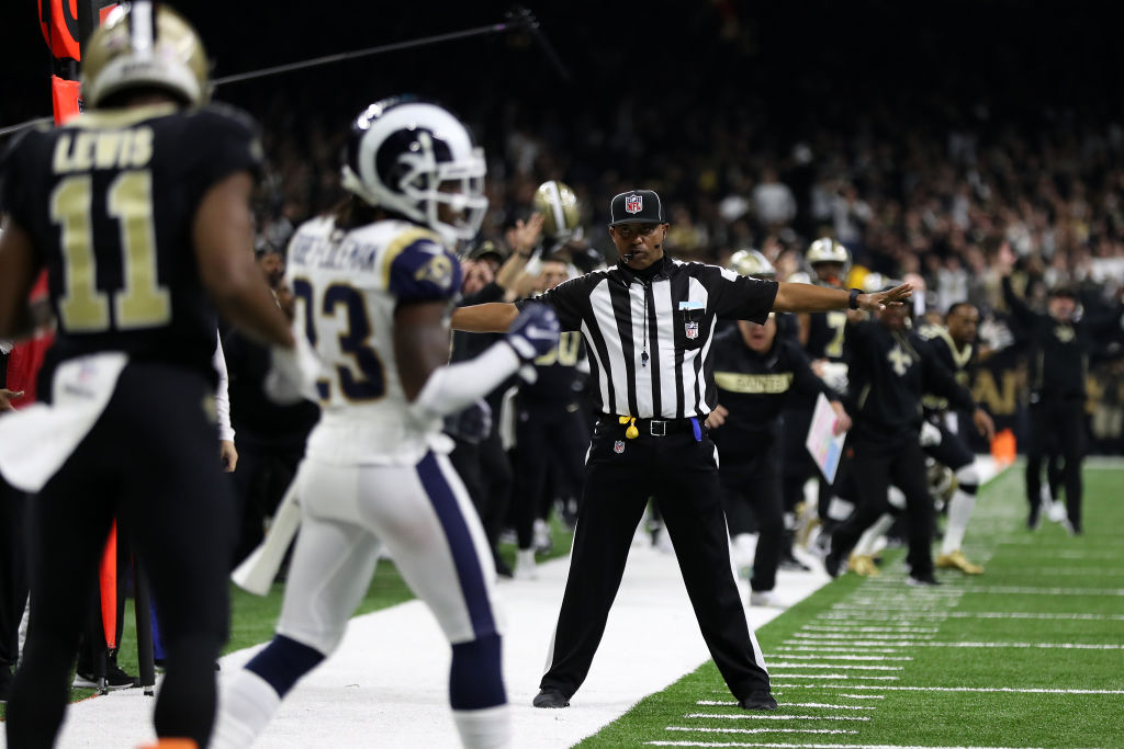 An NFL referee makes a bad incomplete pass call during a game.