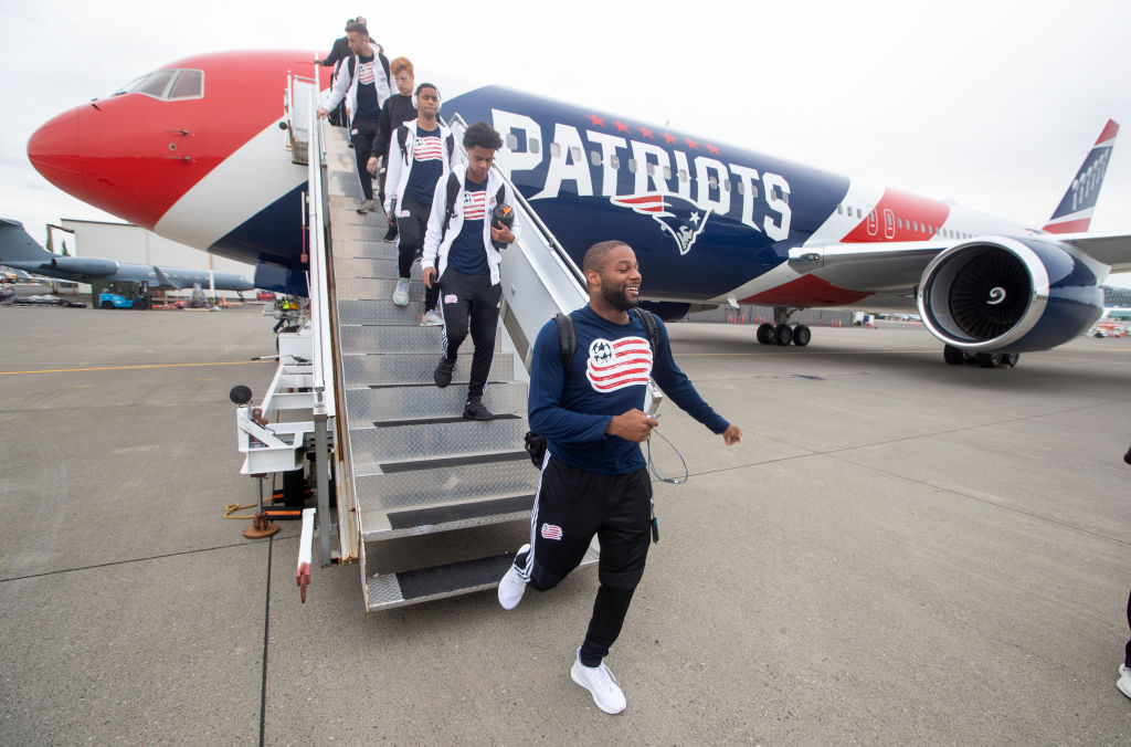Athletes exit from the Patriots charter plane
