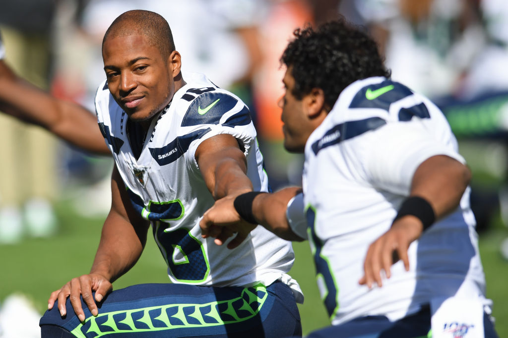 Wide receiver Tyler Lockett of the Seattle Seahawks bumps fists with quarterback Russell Wilson