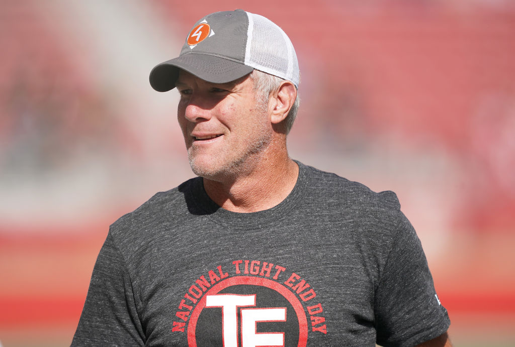 Brett Favre walking the sideline in street cloths before a game.