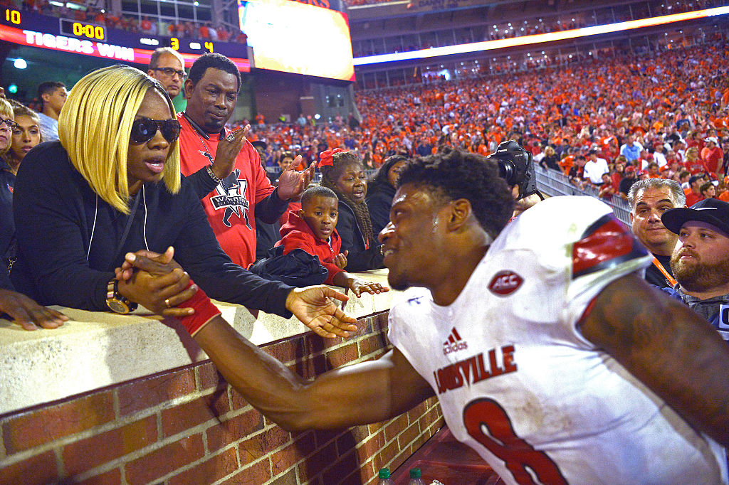 Lamar Jackson speaks with his mother from the field