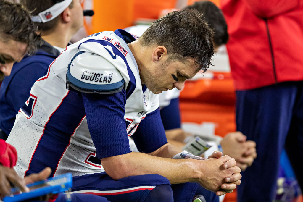 Tom Brady sitting on the bench at the end of a Patriots game.