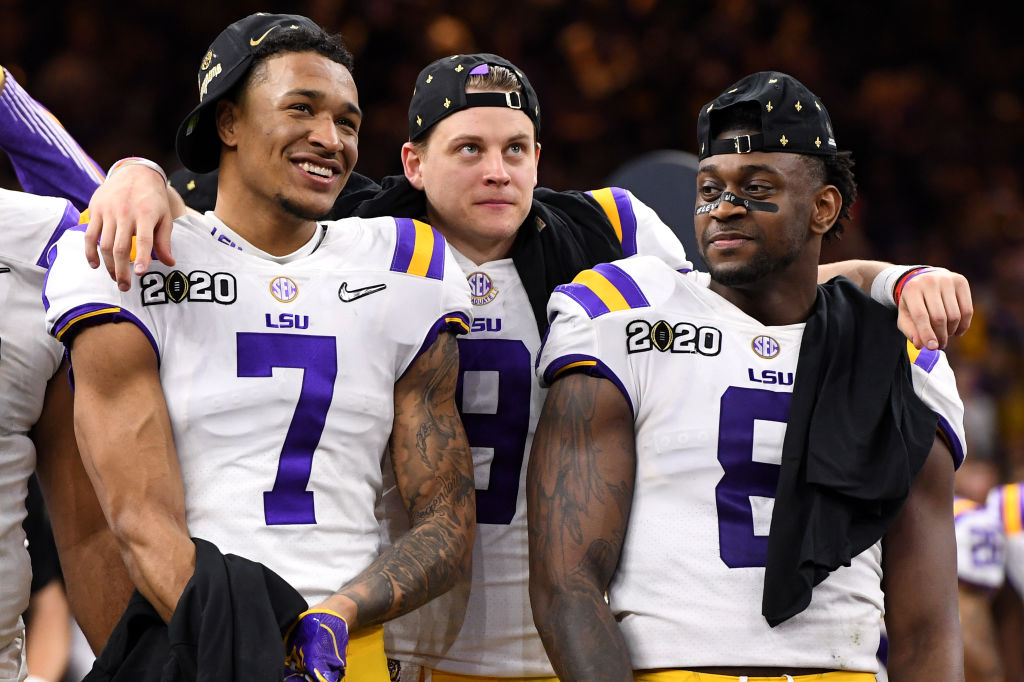 Grant Delpit, Joe Burrow, and Patrick Queen of the LSU Tigers celebrate after winning the College Football Playoff National Championship