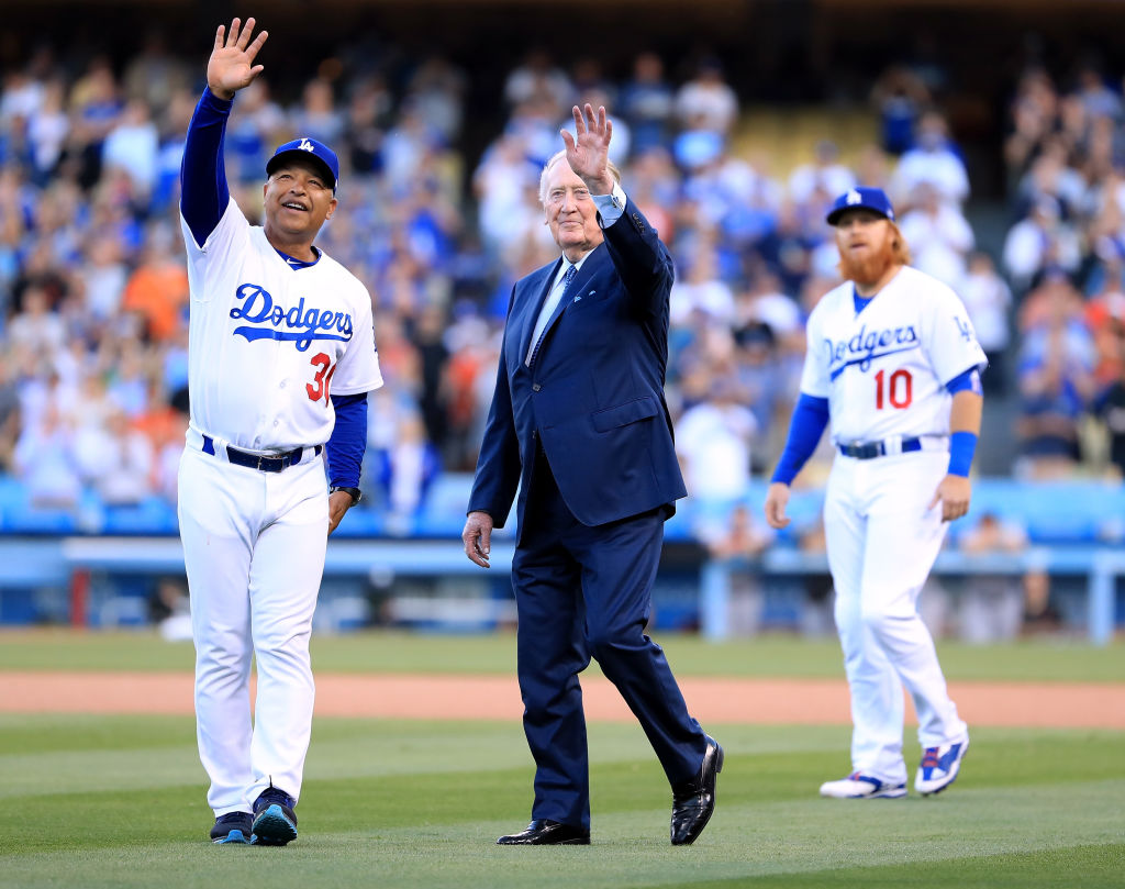 Los Angeles Dodgers manager Dave Roberts and announcer Vin Scully wave to fans