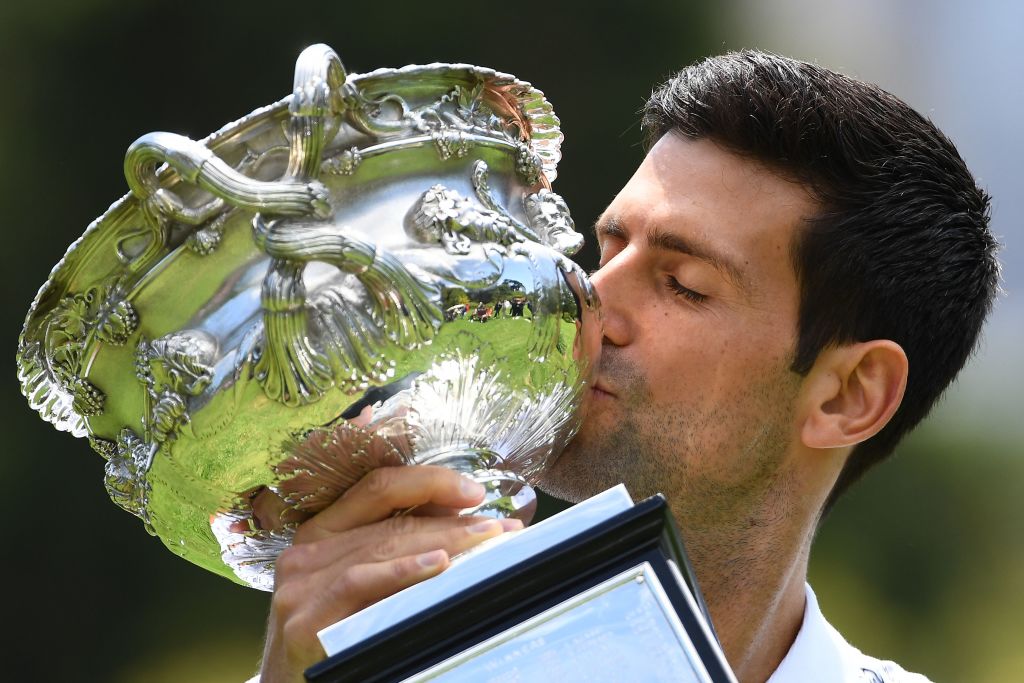 Novak Djokovic kisses a trophy from his most recent victory