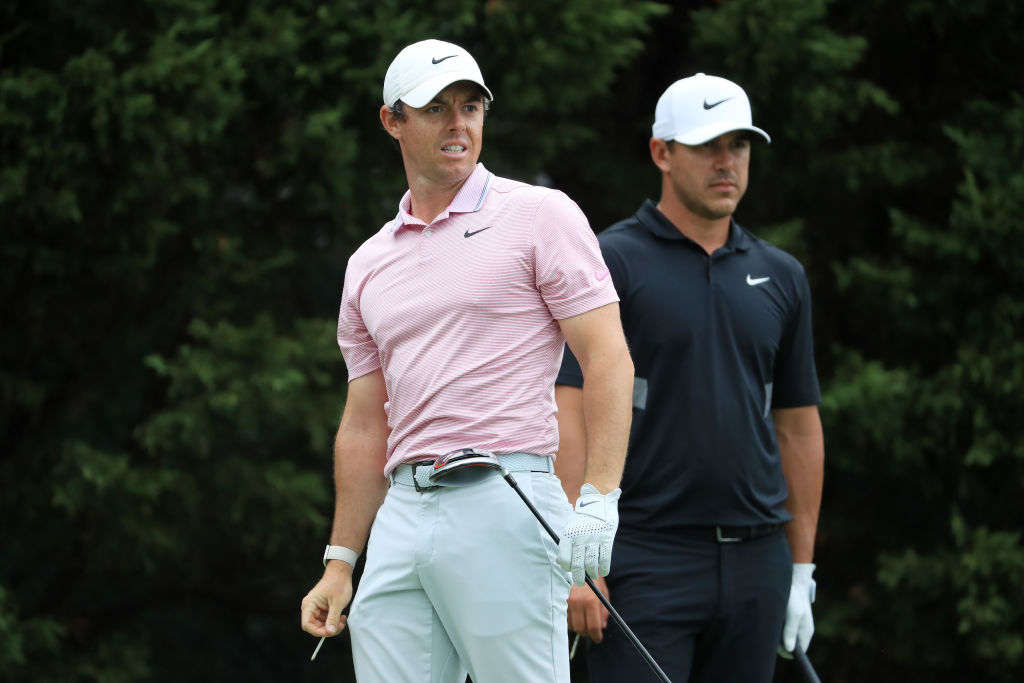 Brooks Koepka and Rory McIlroy look on from the eighth tee