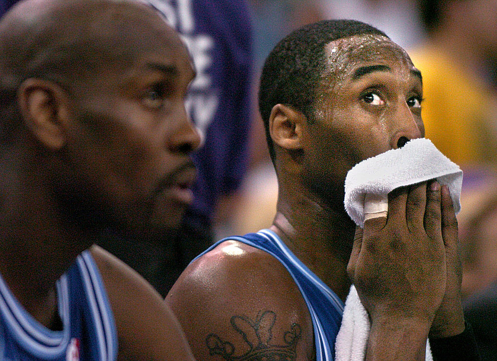 Kobe Bryant wiping sweat off his face on the bench