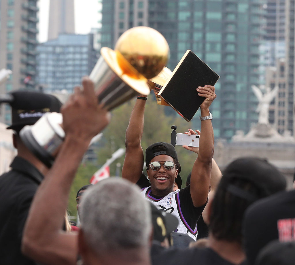 Kyle Lowry hoists the Larry O'Brien NBA Championship Trophy as the Toronto Raptors hold their victory parade in 2019