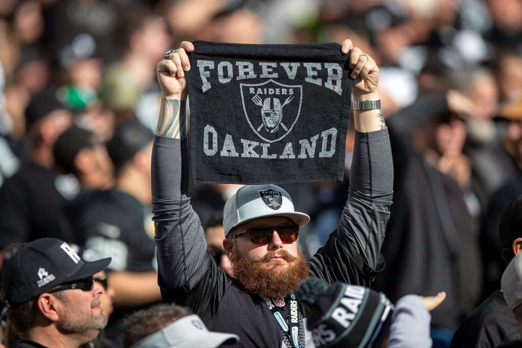 Raiders fan holds up "Forever Oakland" towel. 