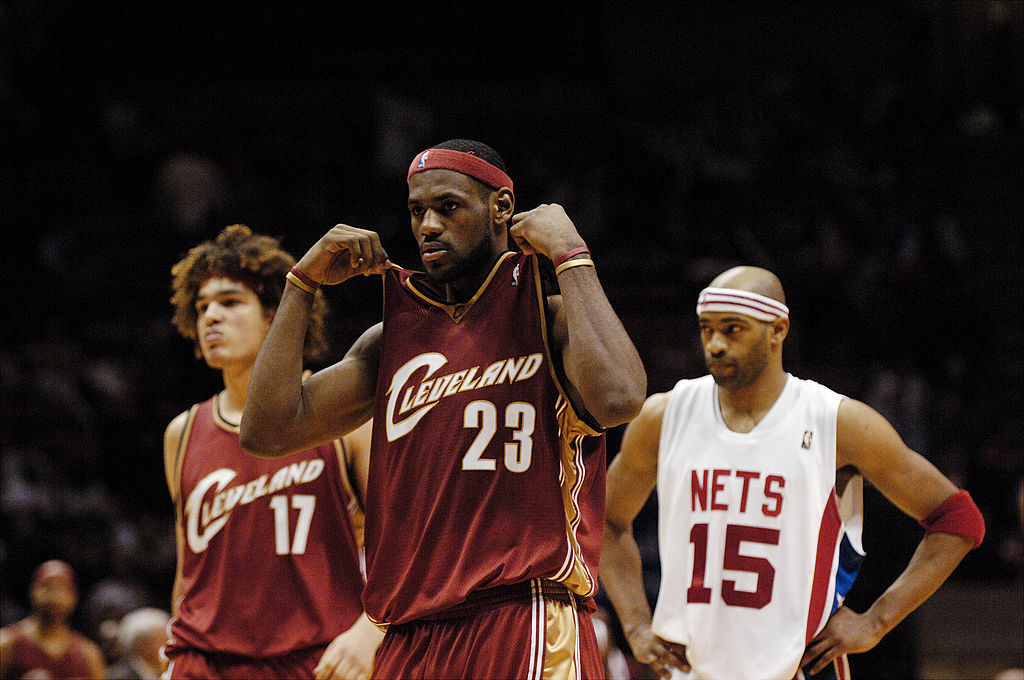 Cleveland Cavaliers' Anderson Varejao (L) and LeBron James walk past New Jersey Nets' Vince Carter (R)