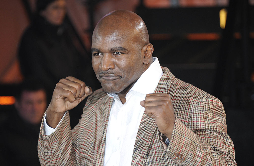 Evander Holyfield posing for a picture on the red carpet holding his hands up in a boxing stance