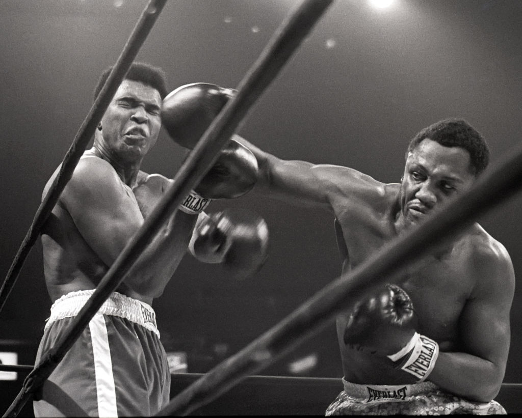 Muhammad Ali takes a hit from Joe Frazier during a match