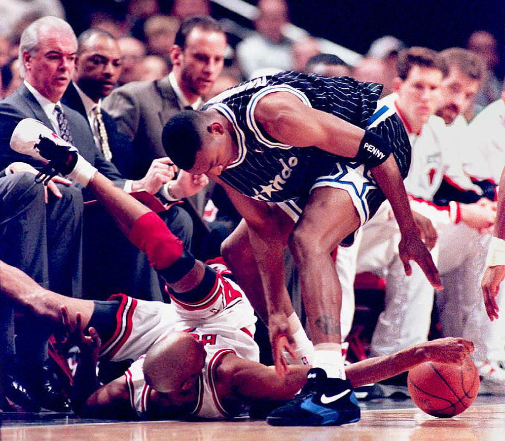 Chicago Bulls guard Ron Harper (L) regains control of the ball after getting knocked to the floor by Orlando Magic guard Anfernee Hardaway
