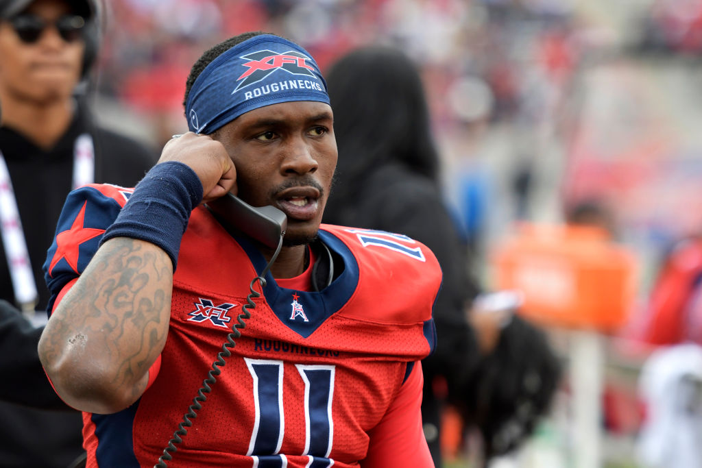 PJ Walker talking with a coach through a phone on the sideline