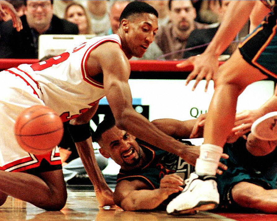 Bulls forward Scottie Pippen and Pistons forward Grant Hill scramble for a loose ball