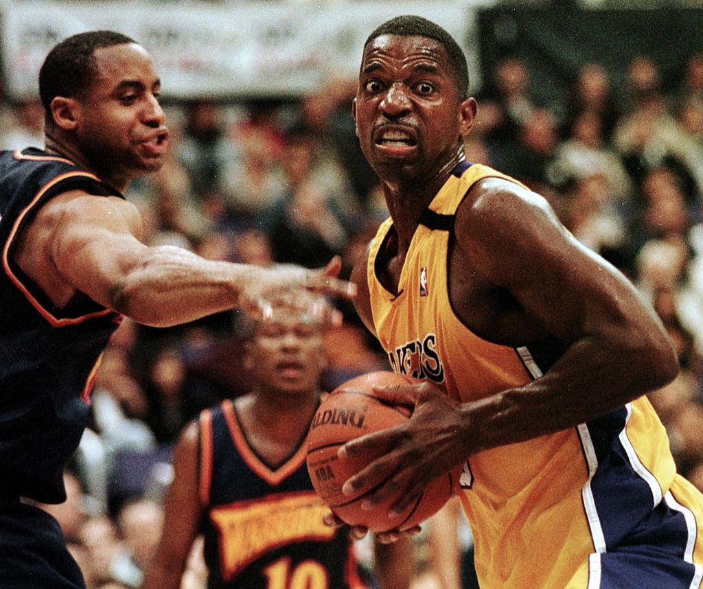 A.C. Green (R) of the Lakers grabs a rebound past Jason Caffey of the Warriors