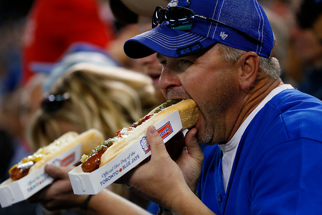 An MLB fan enjoys a hot dog