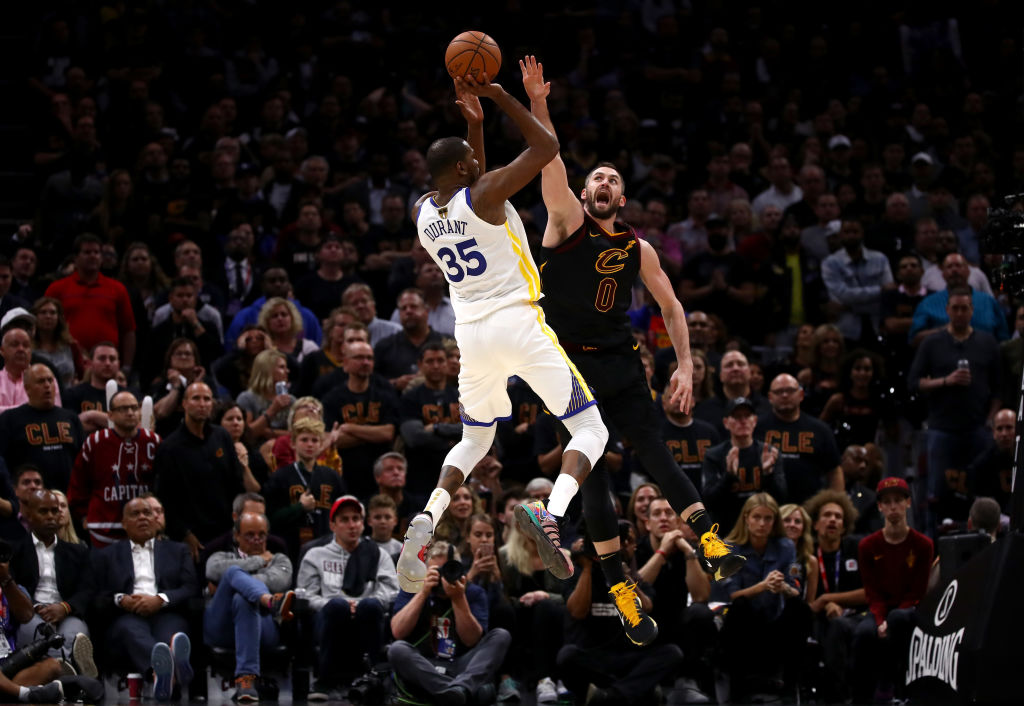 Kevin Durant of the Golden State Warriors attempts a jumper over Kevin Love of the Cleveland Cavaliers