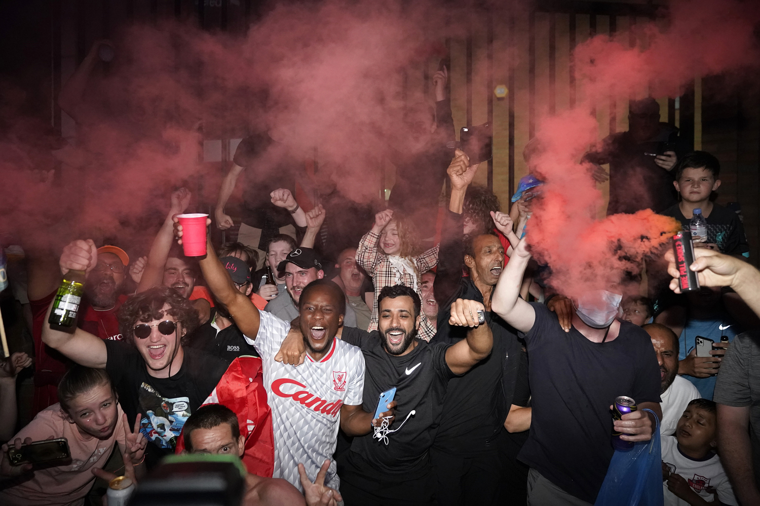 Liverpool fans celebrate Chelsea's victory against Manchester City, which ensured Liverpool of capturing its first Premier League title since 1990. | Christopher Furlong/Getty Images