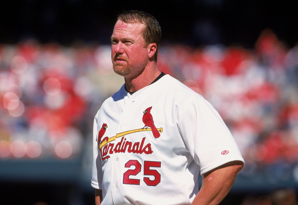 Mark McGwire stands on the St. Louis Cardinals field between pitches.