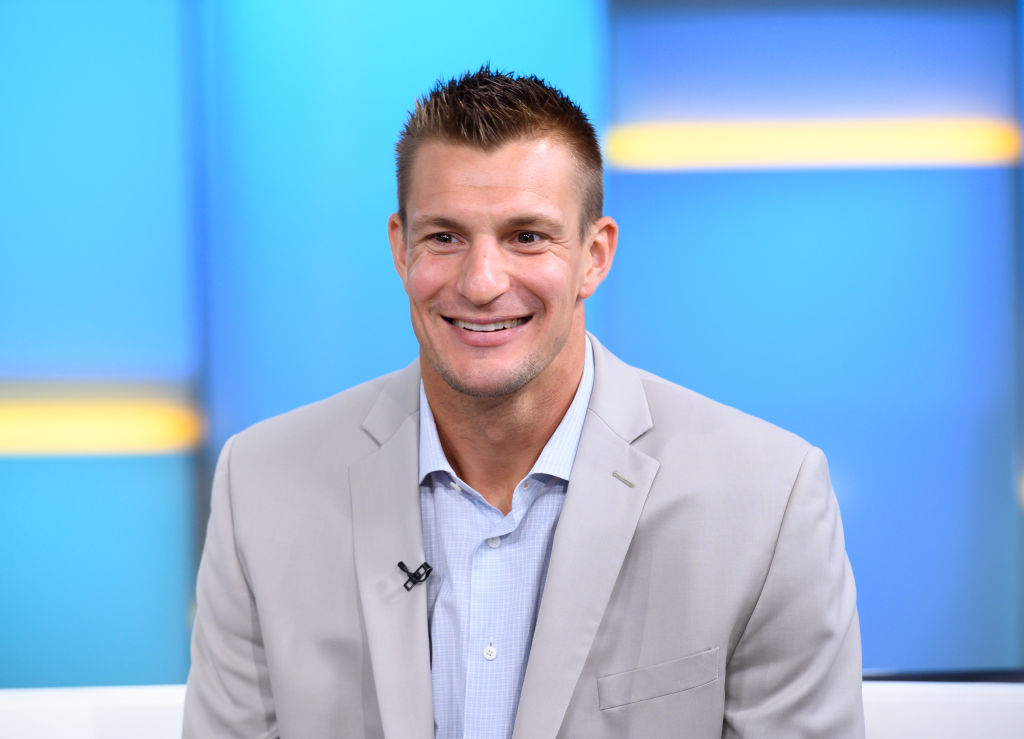 Rob Gronkowski sits in a suit on a television show