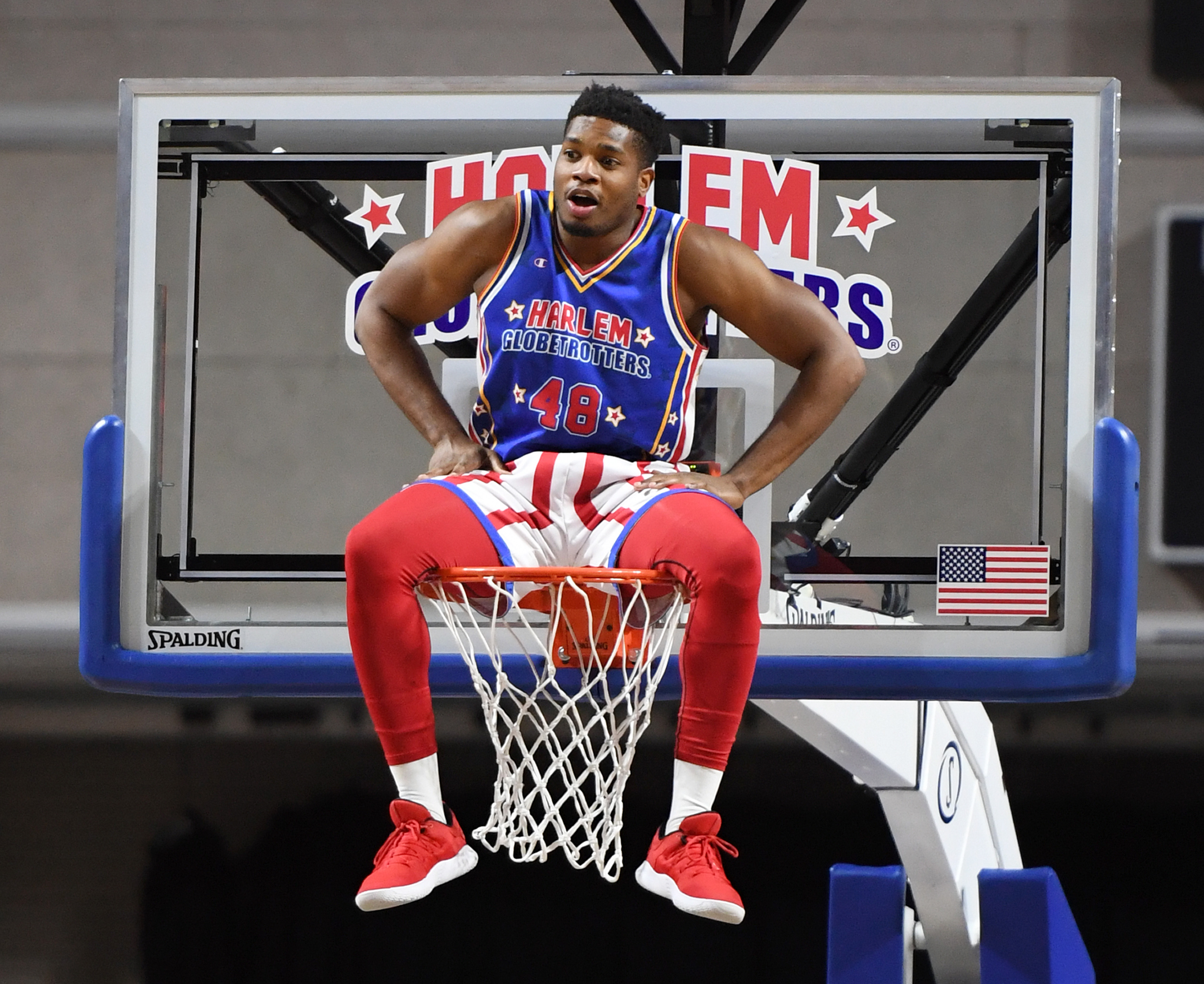 Antjuan "Clutch" Ball of the Harlem Globetrotters sits on the rim