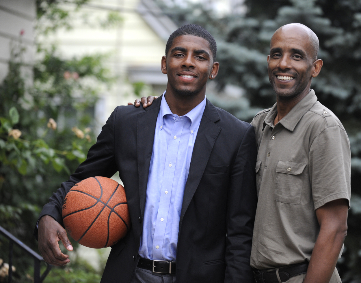 Kyrie Irving posing for a photo with his father