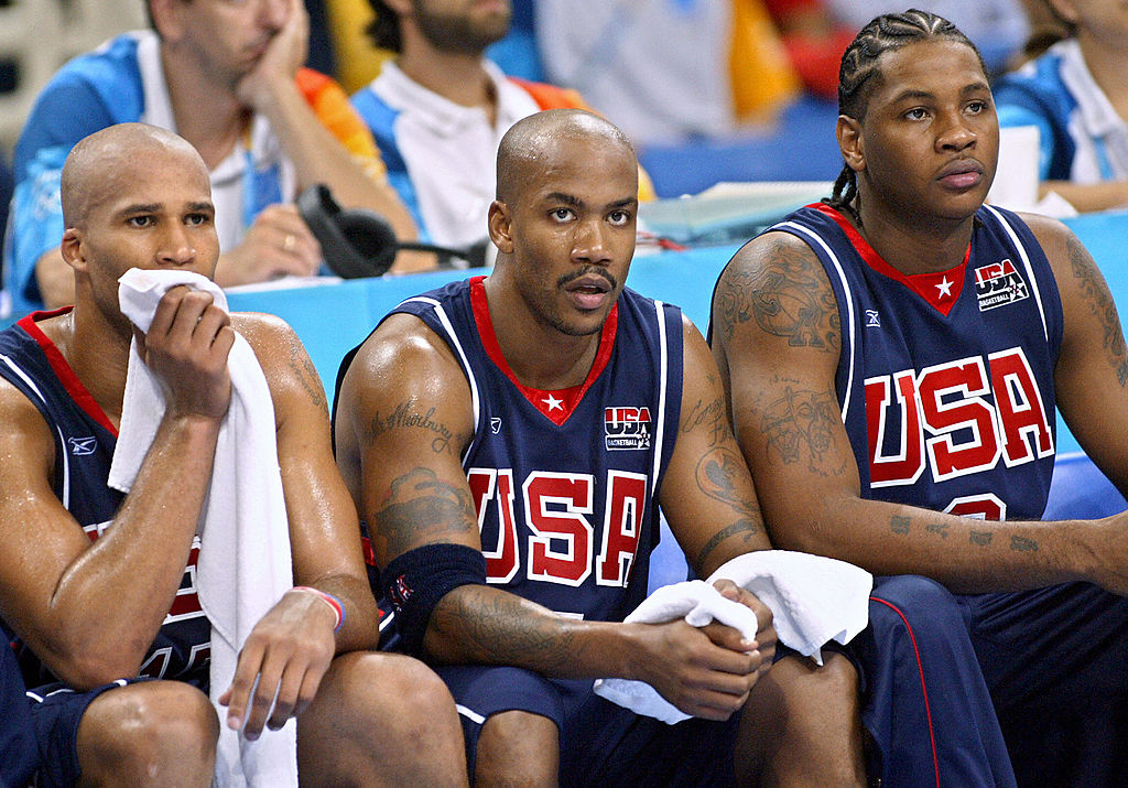 Richard Jefferson (L), sits on the bench next to American teammates Stephon Marbury and Carmelo Anthony