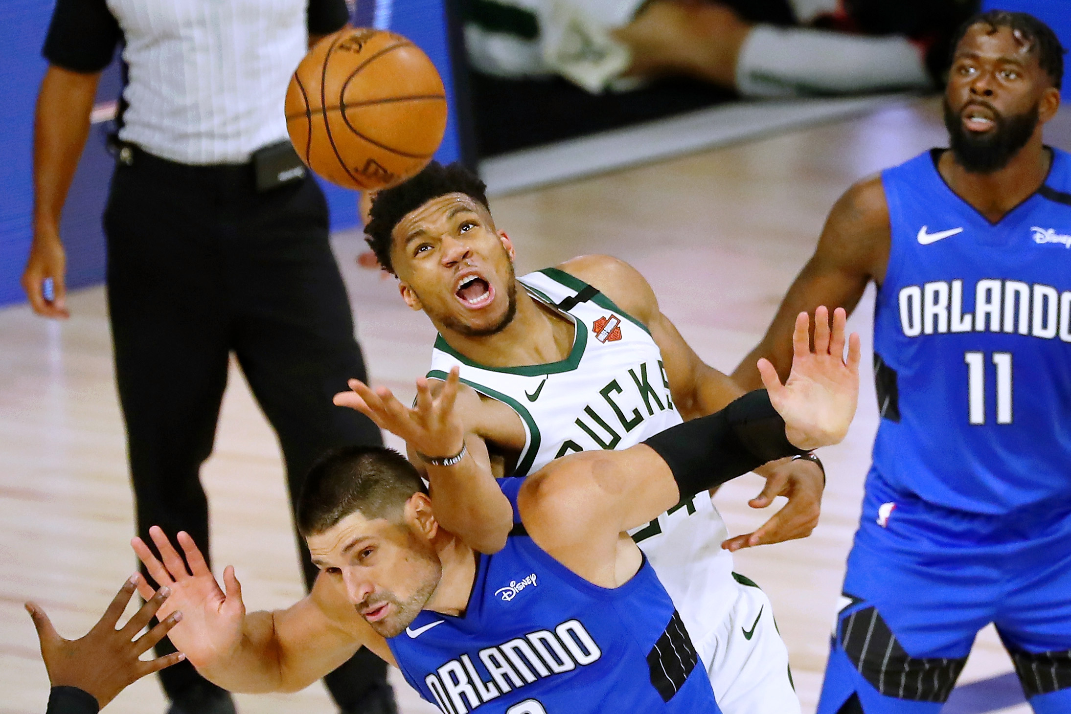 Giannis Antetokounmpo of the Milwaukee Bucks fouls Nikola Vucevic