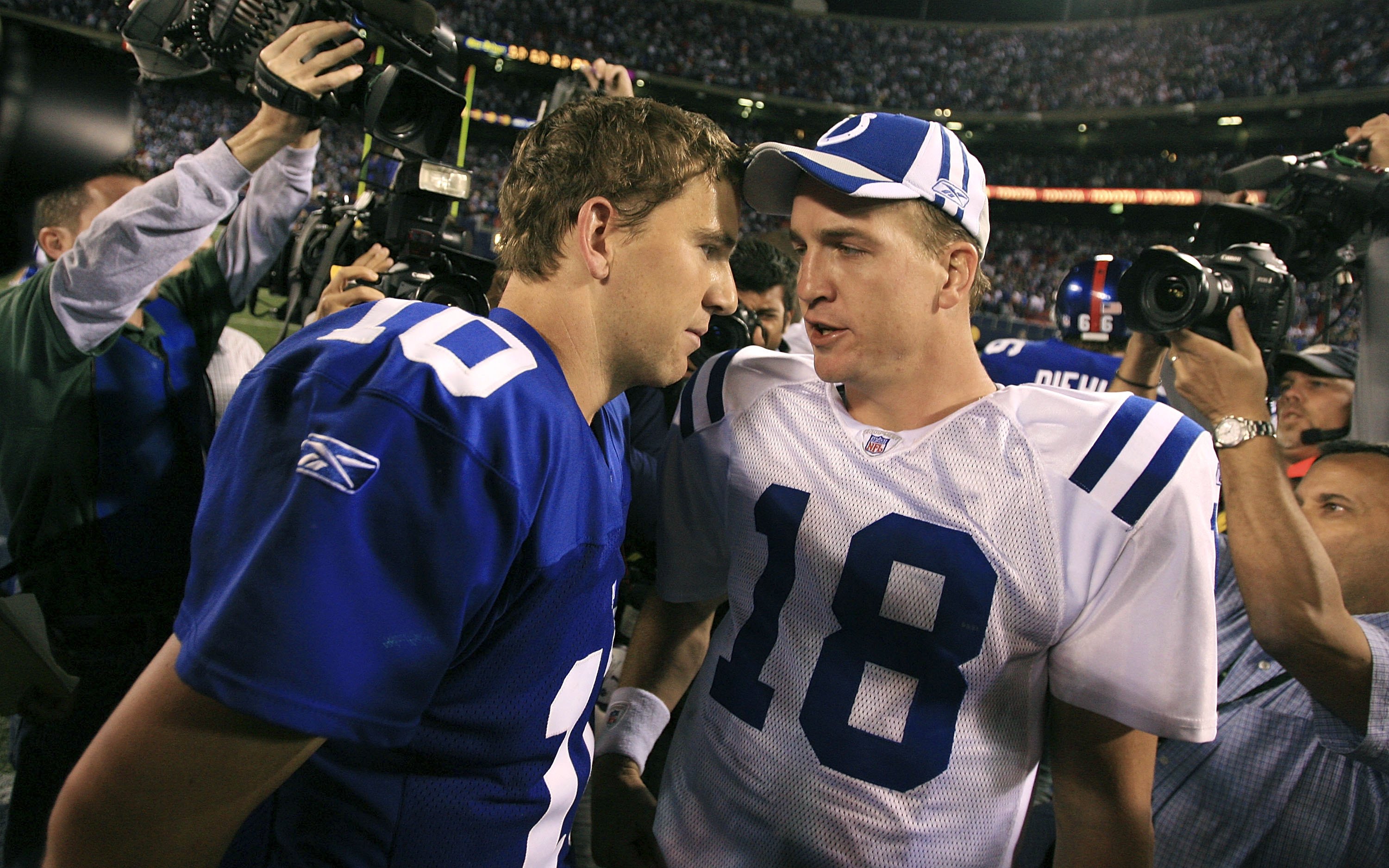 Eli and Peyton Manning talking after playing each other in an NFL game