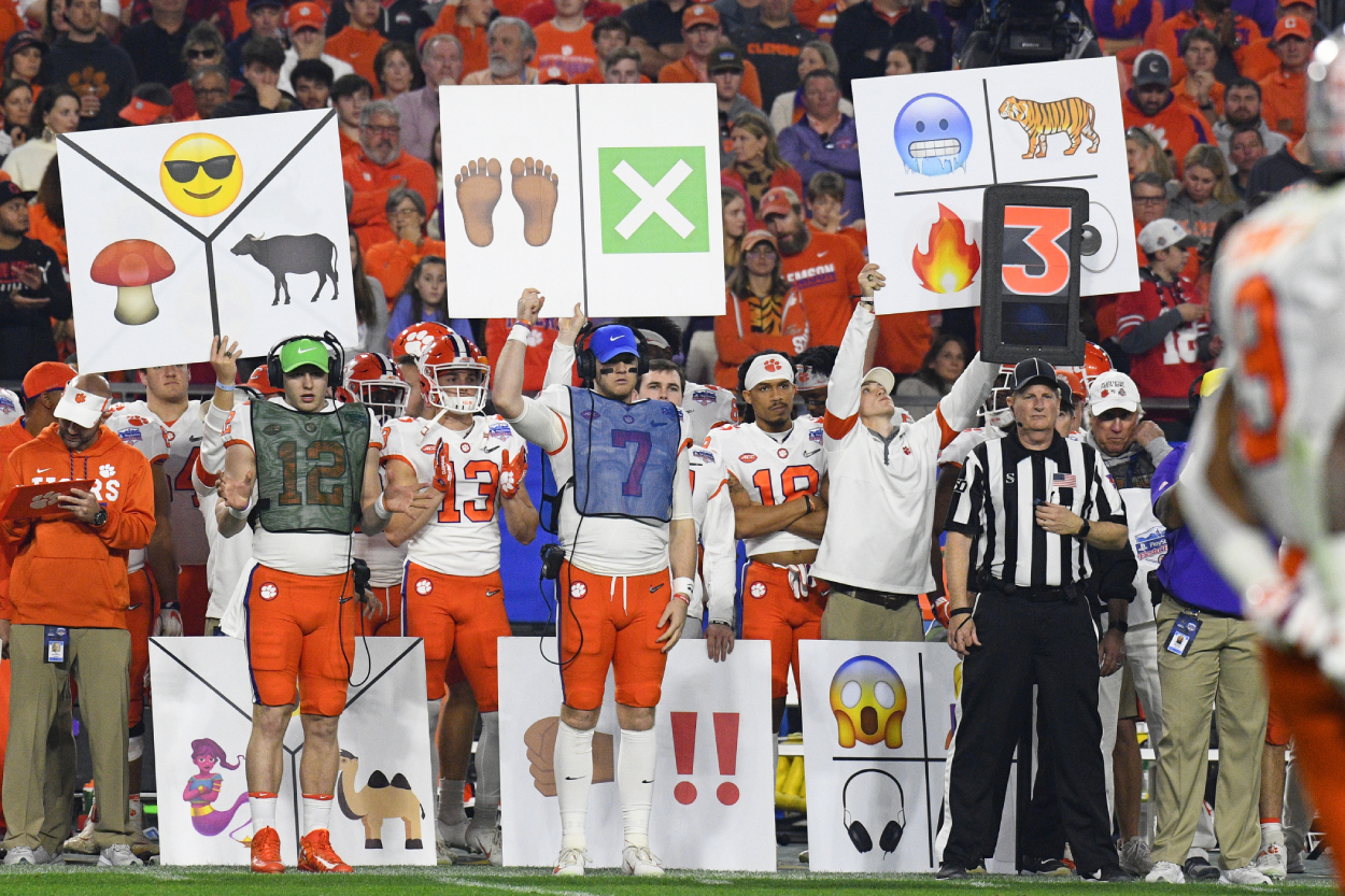Players for Clemson hold up signs during a college football game