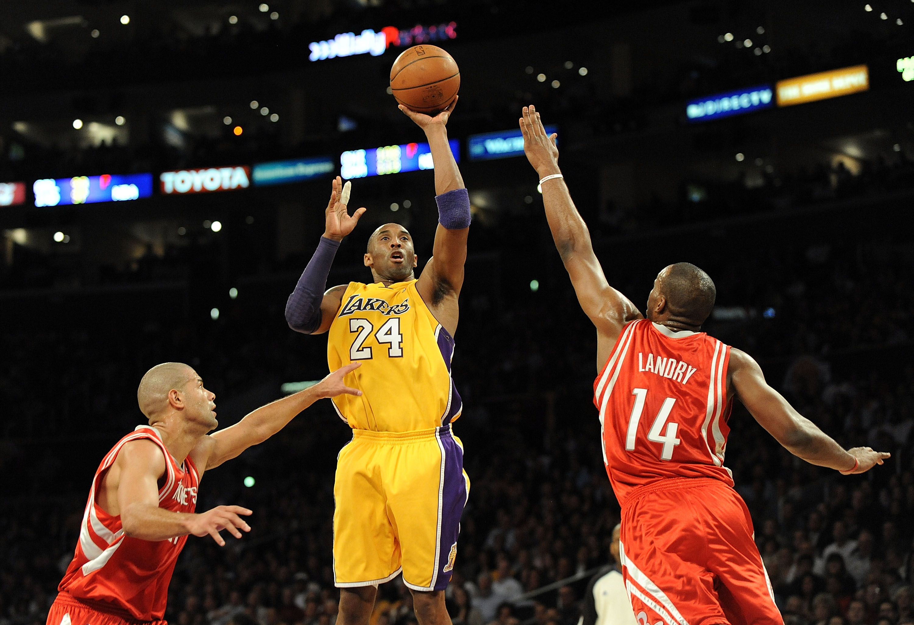 Kobe Bryant shooting a jump shot over two defenders