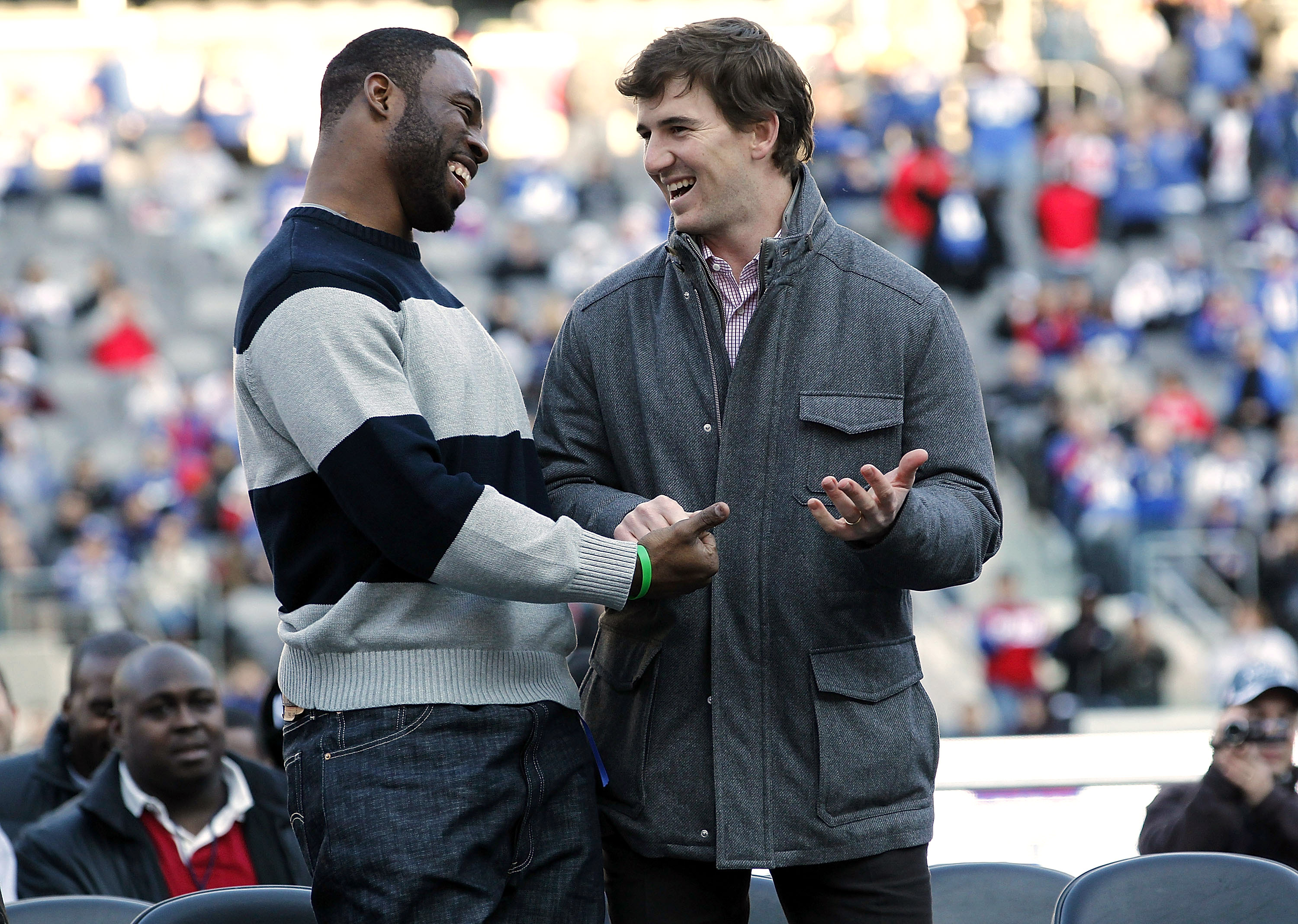 Justin Tuck (L) laughs with teammate Eli Manning at a rally to celebrate the New York Giants' event