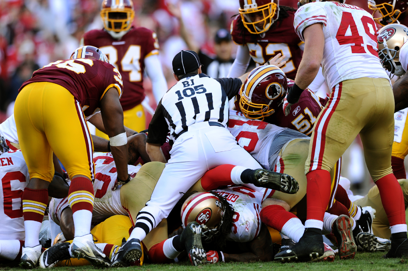 What happens at the bottom of an NFL pile after a fumble?