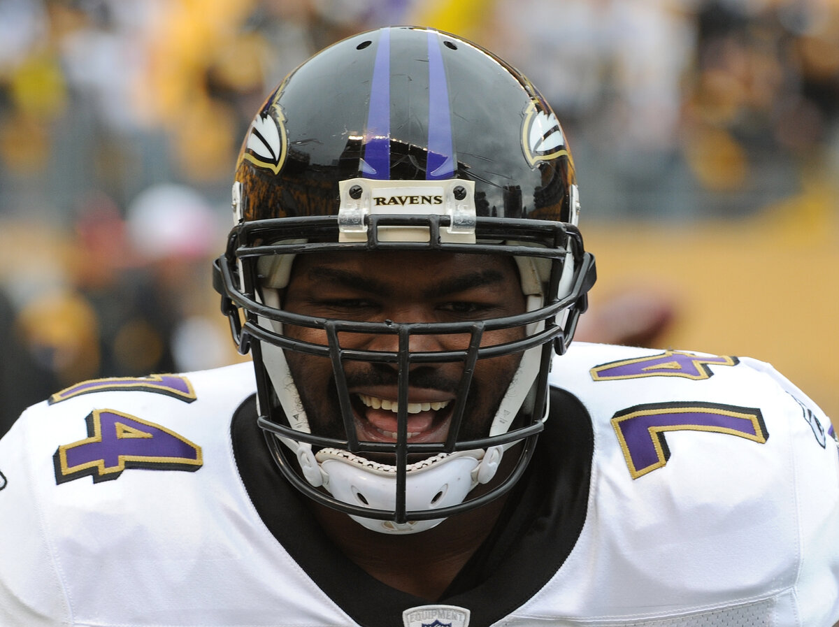 Michael Oher smiles through his helmet before a play for the Ravens