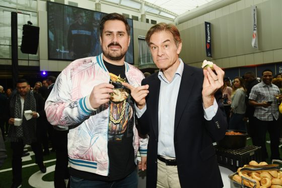 Dan "Big Cat" Katz and Dr. Oz hold up food at a media event