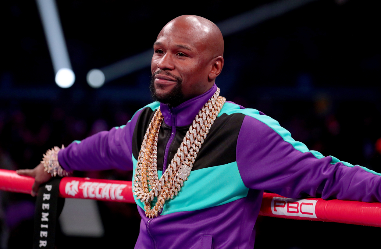 Floyd Mayweather smiles as he leans against the ropes