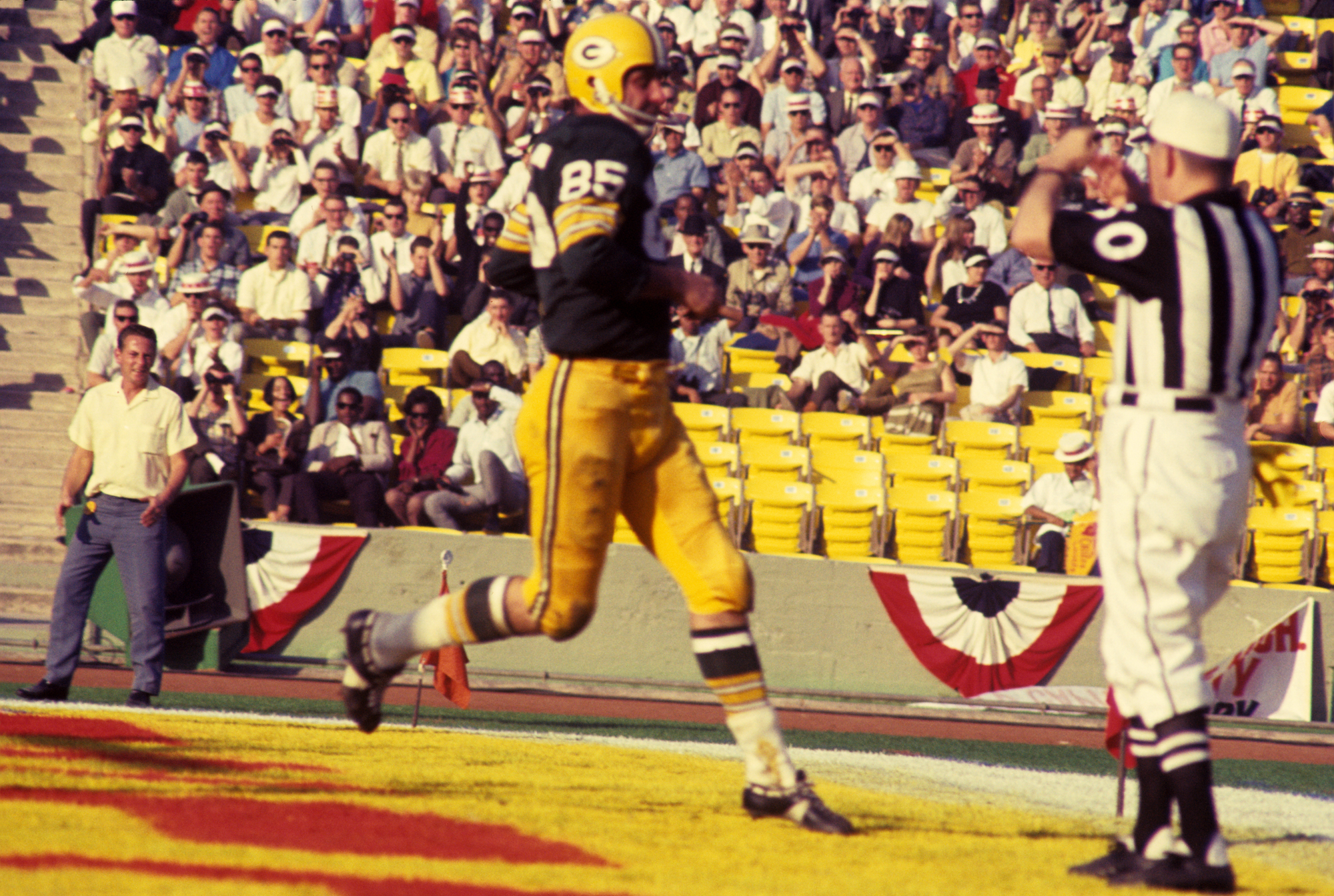 Wide receiver Max McGee, #85 of the Green Bay Packers, scores on a 13-yard touchdown pass from quarterback Bart Starr in the third quarter of Super Bowl I on January 15, 1967, against the Kansas City Chiefs at the Los Angeles Memorial Coliseum in Los Angeles, California.