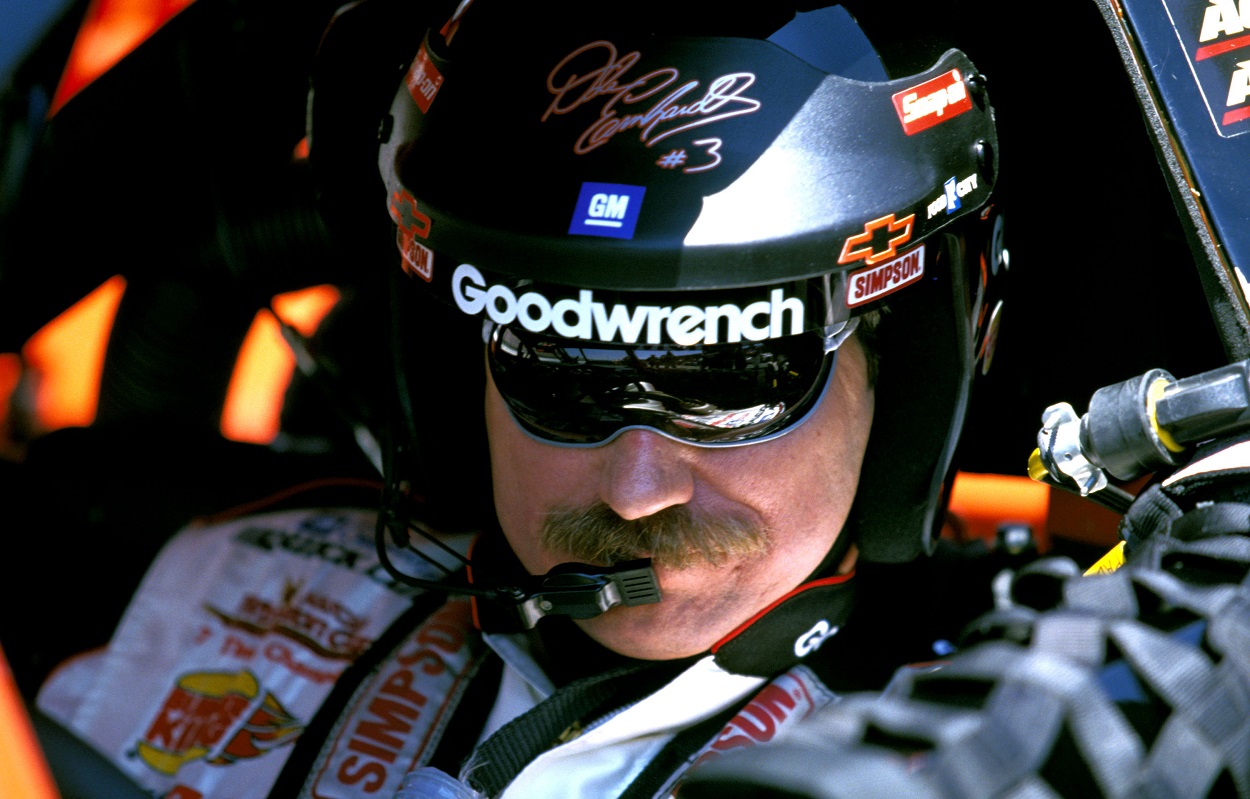 Dale Earnhardt looks down at his steering wheel while wearing his helmet before a race