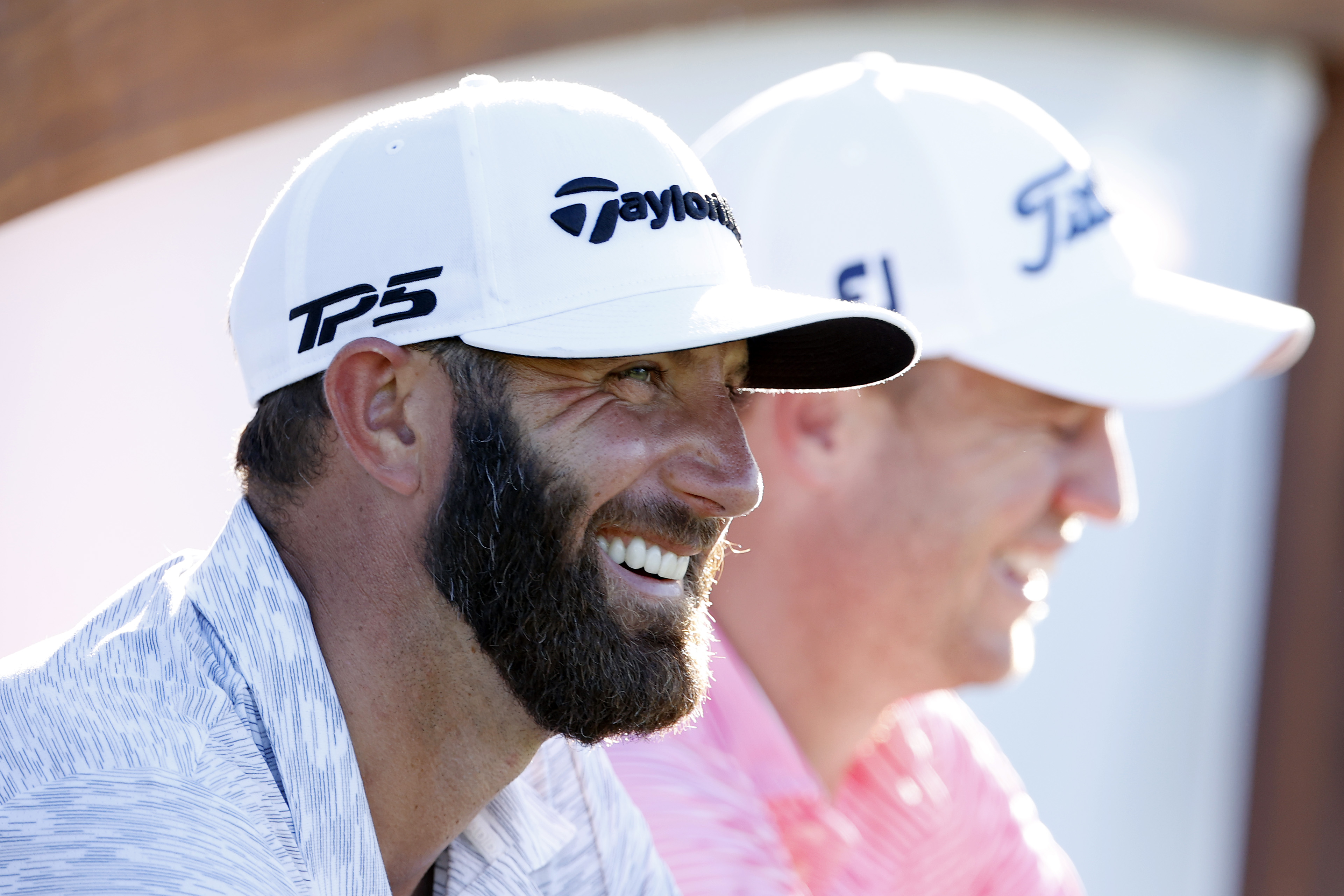 Dustin Johnson laughs as they wait on the 18th tee during the 2021 Sentry Tournament Of Champions