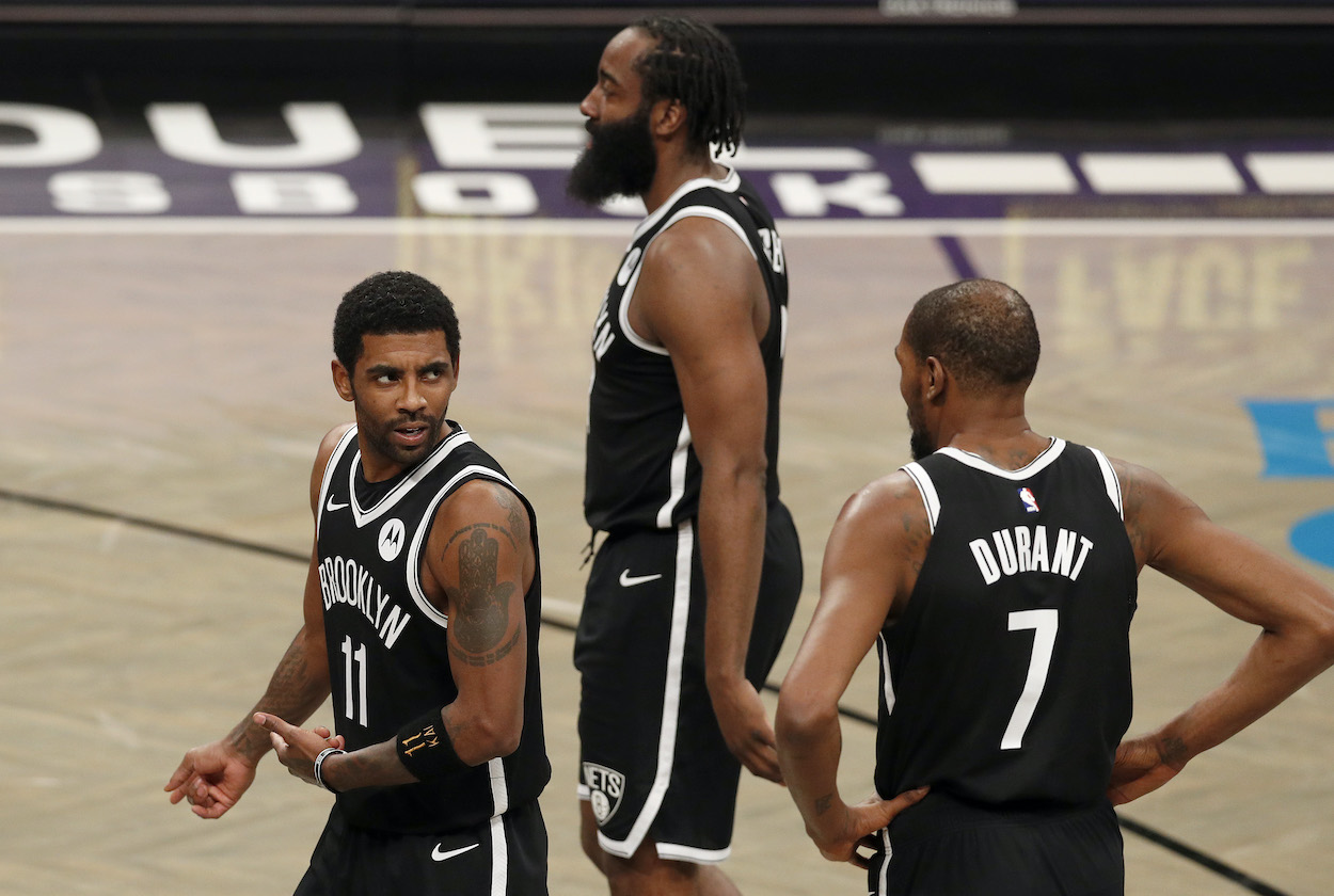 Kyrie Irving, James Harden, and Kevin Durant of the Brooklyn Nets talk during a game against the Miami Heat