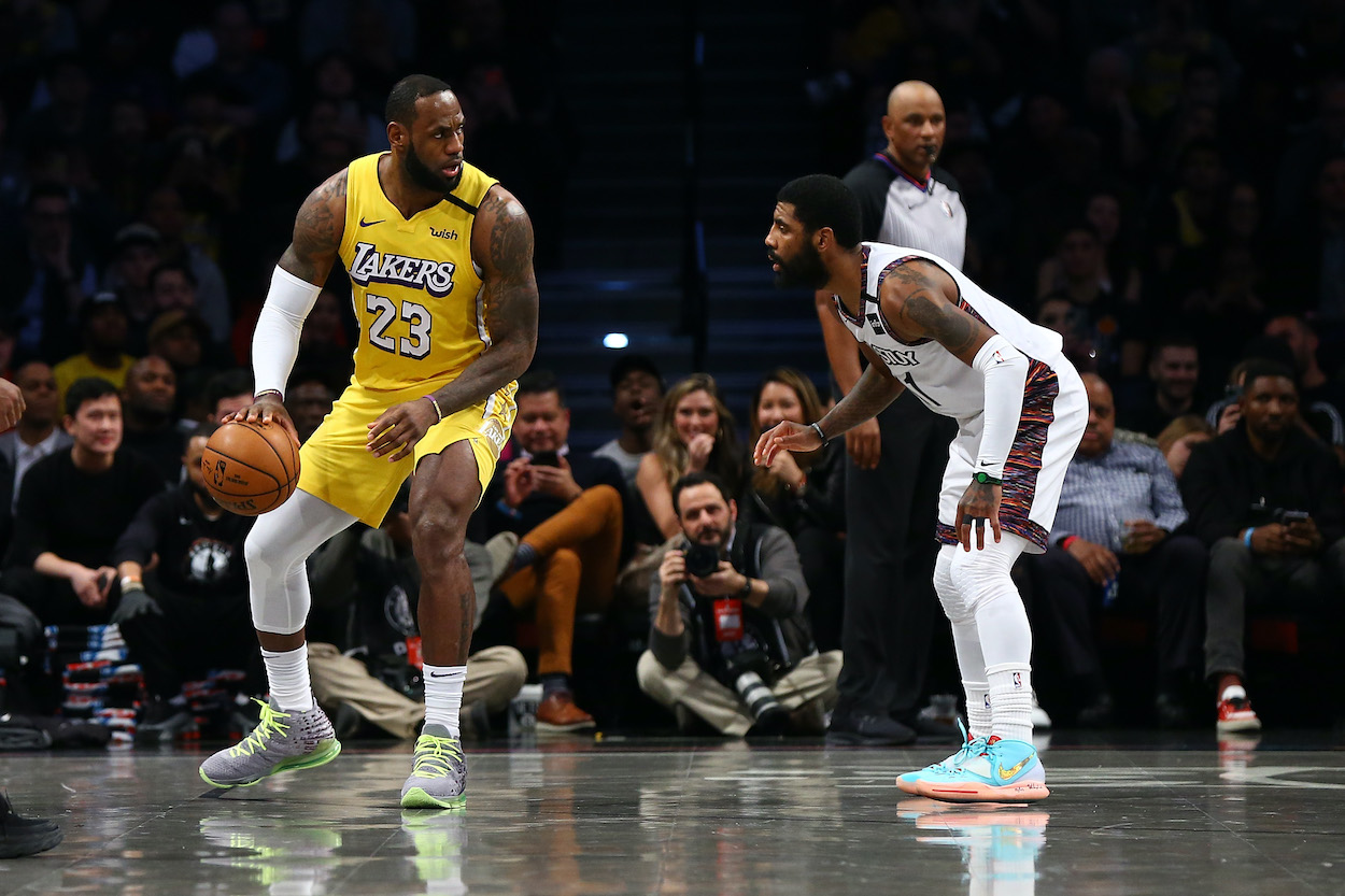 LA Lakers forward LeBron James backs down Brooklyn Nets guard Kyrie Irving