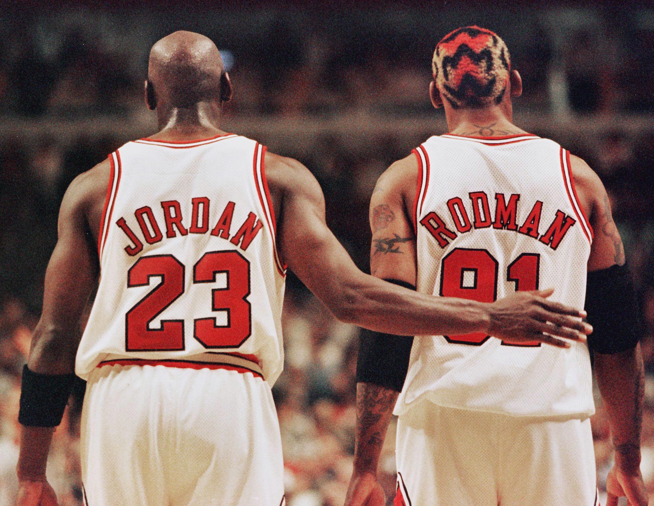 Michael Jordan (L) pats Dennis Rodman, both of the Chicago Bulls, on the back after Rodman was called for a technical foul