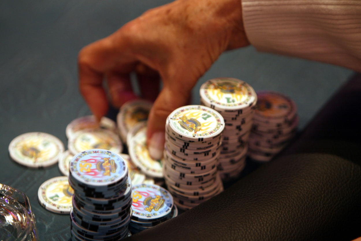 Seorang pemain poker bersiap untuk melempar beberapa chip ke dalam pot