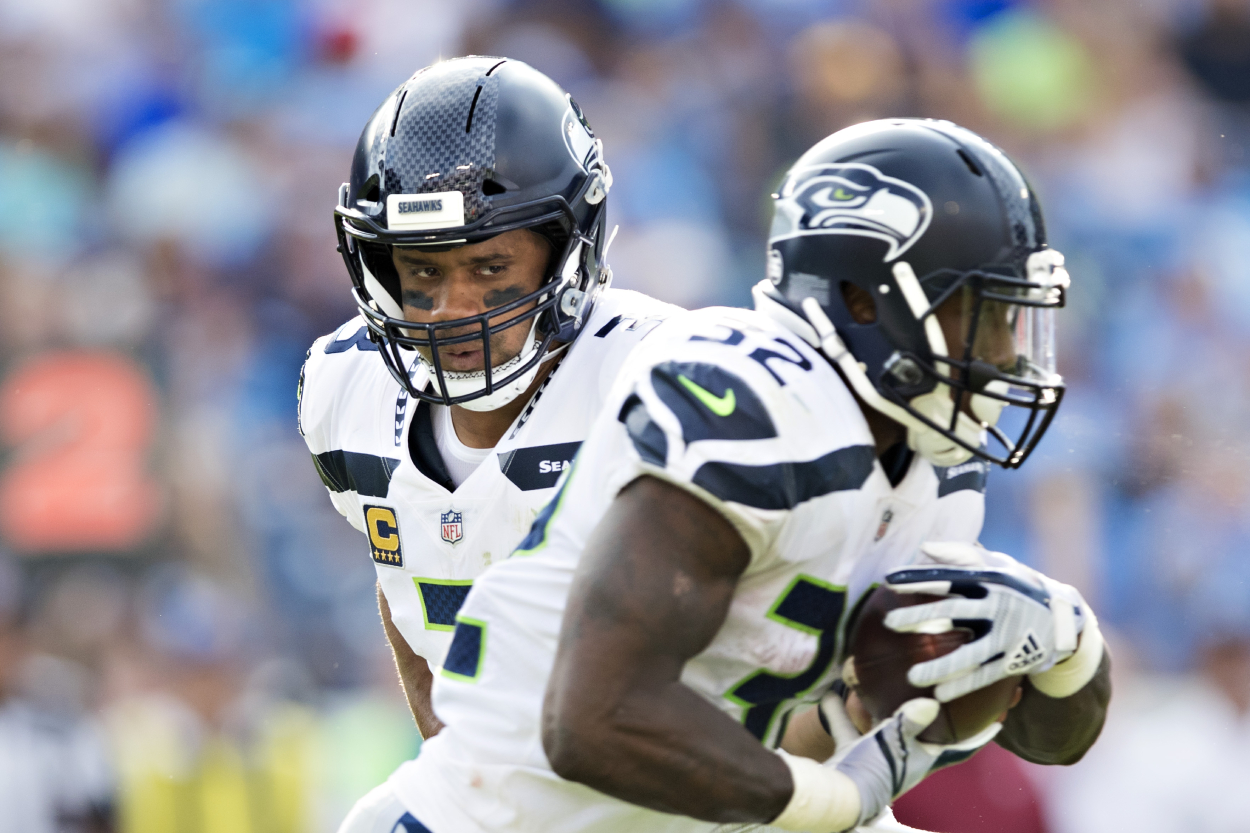 Seahawks quarterback Russell Wilson hands the ball off to running back Chris Carson.