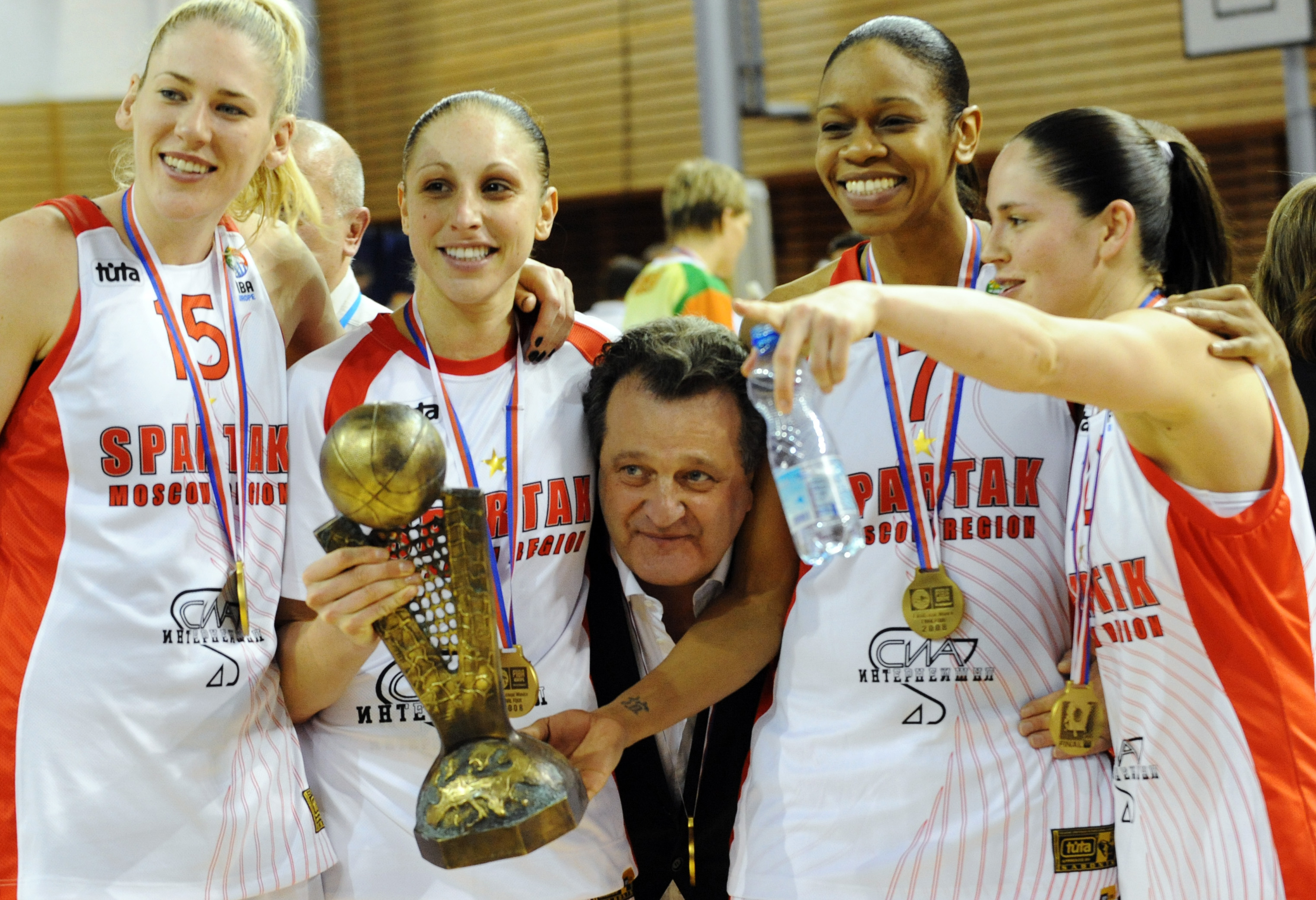 The owner of Spartak Moscow Shabtai Kalmanovic (C) pokes his head between his players (From L) Lauren Jaskcon, Diana Taurasi, Tina Thomson, and Sue Bird as they celebrate their victory in the final of the Euroleague Women's Final Four 2008 basketball game
