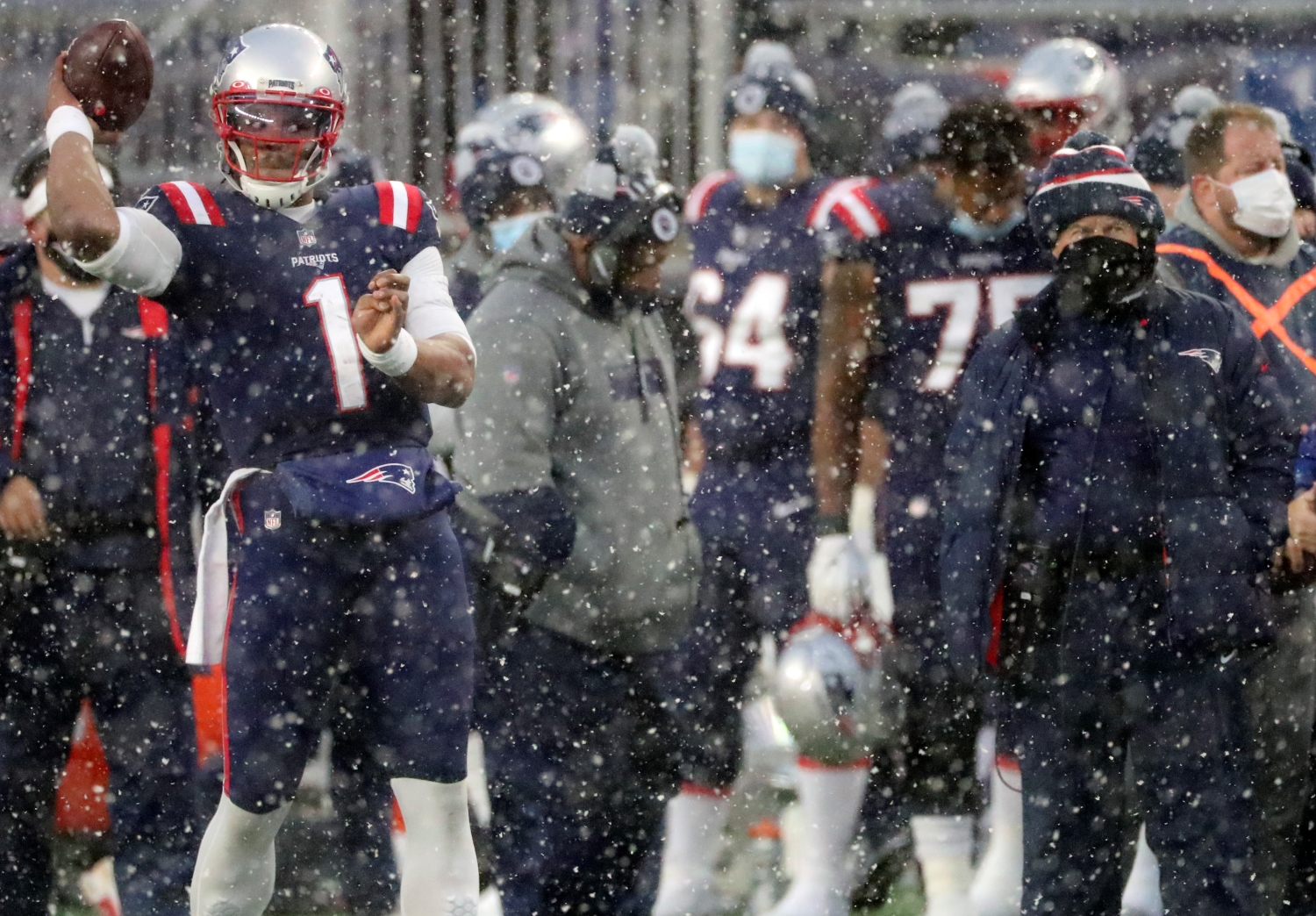 New England Patriots quarterback Cam Newton throws on the sidelines in front of head coach Bill Belichick against the New York Jets at Gillette Stadium.